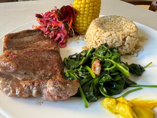 Steak with spinach, corn, cabbage salad and corn 