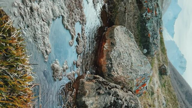 Narzan drinking spring in Ossetia. The bubbling water of a natural mineral spring against the background of a red rocky bottom. The healing water of the Narzan Valley. North Caucasus, Russia. 4K