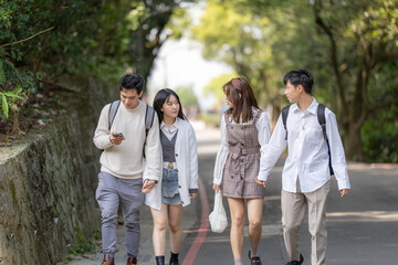 Scenery of four Taiwanese college students walking while talking in the nature of the Maokong, a tourist attraction in Wenshan District, Taipei City, Taiwan 台湾台北市文山区の観光名所の猫空の自然の中を台湾人の大学生の男女四人が話しながら歩く風