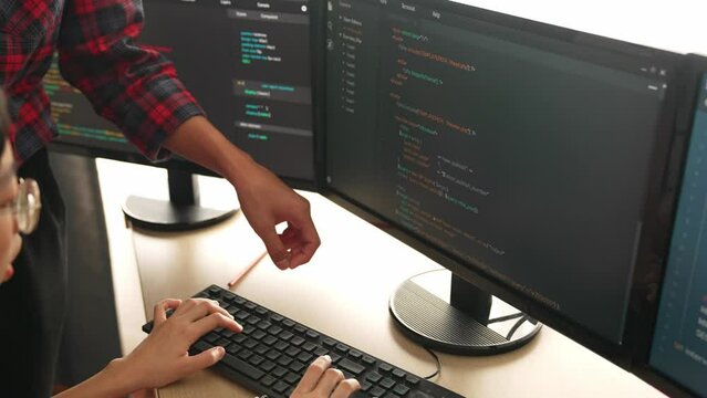 Slow motion back end or software developer manager supervising his team on new application program development on debugging and solving complex code algorithms on monitor. Burgeoning