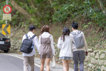 Scenery of four Taiwanese college students walking while talking in the nature of the Maokong, a tourist attraction in Wenshan District, Taipei City, Taiwan 台湾台北市文山区の観光名所の猫空の自然の中を台湾人の大学生の男女四人が話しながら歩く風