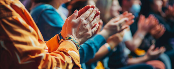 Audience clapping their hands at a large event