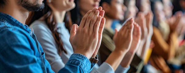 Audience clapping their hands at a large event