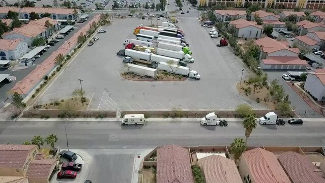 Aerial flyover residential Semi Truck parking lot ending at Casino parking lot on busy street.