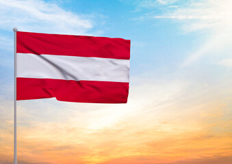 3D illustration of a Austria flag extended on a flagpole and in the background a beautiful sky with a sunset