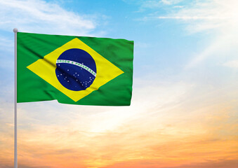 3D illustration of a Brazil flag extended on a flagpole and in the background a beautiful sky with a sunset