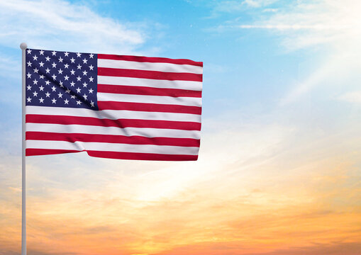 3D illustration of a United States flag extended on a flagpole and in the background a beautiful sky with a sunset