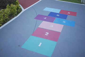 Vibrant hopscotch game painted on urban asphalt surface
