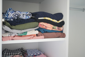  organizing clothes in a closet on shelves for comfort and ease of access