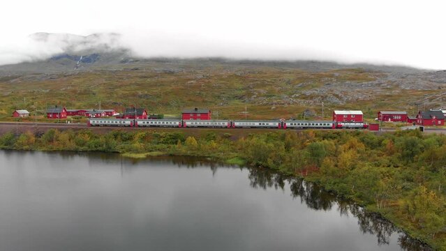 Aerial: swedish passenger train by a lake in northern Sweden