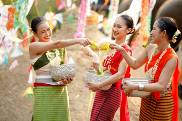 Group of Thai women ware Thai traditional dress play to sprinkle water on the Thai New Year's Day...