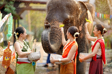 Group of Thai women ware Thai traditional dress play to sprinkle water on the Thai New Year's Day...