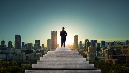 Successful businessman in suit standing on top of the stair. Development and leader in business concept.