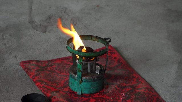 4k footage of the process of lighting a kerosene stove and preparing solid wax that will be used to learn batik. The oil stove is lit and used to melt solid wax so that it can be used to make batik