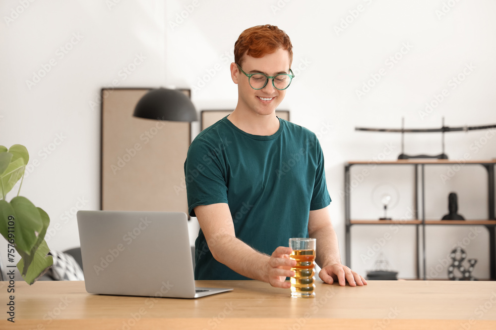 Poster Young man with glass of juice at home