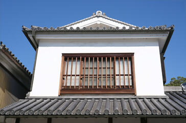Second-floor room windows and traditional roof styles in an old Japanese town.