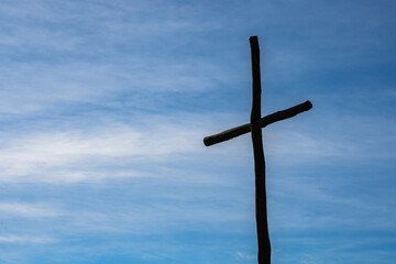Cruz de Jes&uacute;s de Dios con el cielo despejado y azul de fondo cruz hecha de palos de madera recordando la fe y la esperanza en la religi&oacute;n cat&oacute;lica