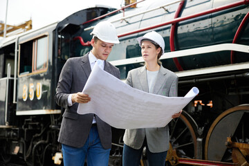 businesspeople meeting and pointing at a train on construction site