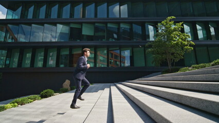 Confident man running stairs up urban street rushing to office. Boss hurrying 