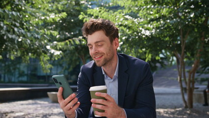 Freelancer coffee looking cellphone screen on street close up. Man enjoy break