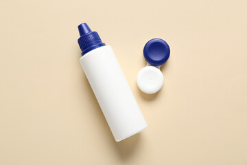 Container for contact lenses with solution on beige background
