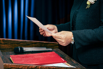 A woman in a suit reads a document at the press conference.