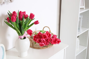 Vase with tulips on commode in living room. Easter celebration