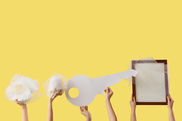 Women with wrapped things and paper key on yellow background. Moving concept