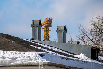 Obraz premium Chimneys on the roof of the building on a winter day