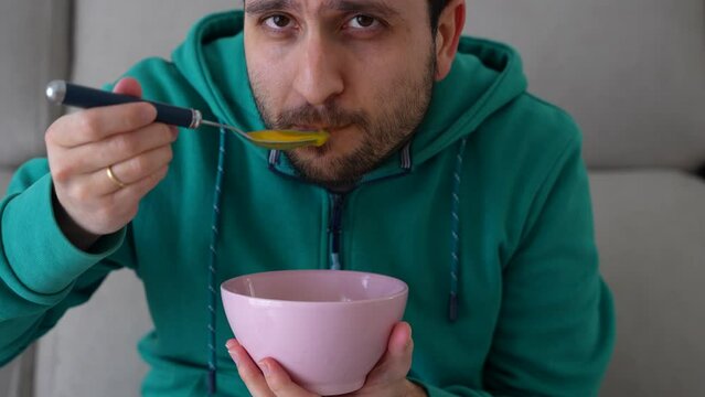 Man trying to eat soup after dentist appointment, can't open mouth because of toothache