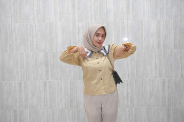 Expression of Asian Indonesian woman wearing hijab and yellow shirt