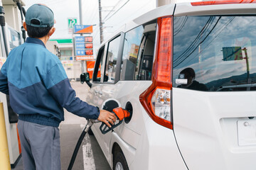 Man hand refuel to car, gasoline fuel nozzle in vehicle at petrol station. Oil Price, petroleum...