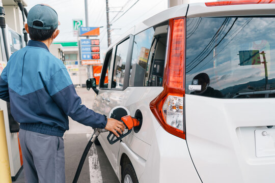 Man hand refuel to car, gasoline fuel nozzle in vehicle at petrol station. Oil Price, petroleum economy, inflation and commodity concept