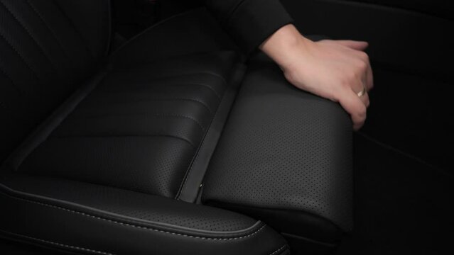 the texture of the interior trim of the car. The design of the car seat. A hand touches the seat of a premium car. A hand strokes the upholstery of a car seat