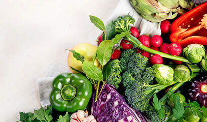 Table with vegetables on a light wood background. Pepper, cabbage, broccoli, radish, garlic. Healthy eating concept