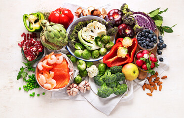 Vegetables, fish, berry on wooden background. Healthy food concept