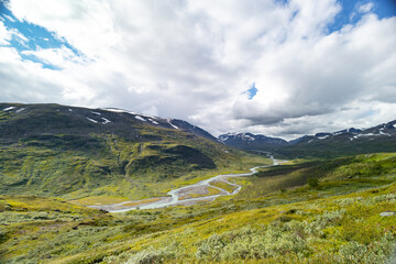 A beautiful Rapa river Rapadalen landscape with native plants. A mountain river from above in Sarek National Park, Sweden. Summer sceney of Northern Europe.