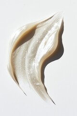 Swirl of Shimmering Cosmetic Highlighter With Scattered Particles on a White Background