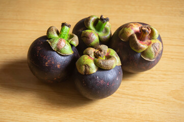 Fresh mangosteen fruit on a wooden patterned table
