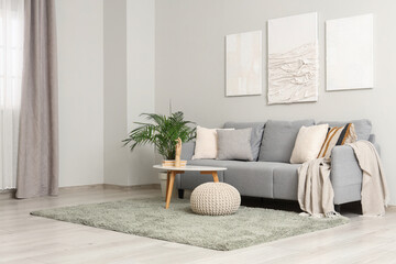 Interior of living room with sofa, pictures and coffee table