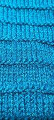 Blue knitted background. The textured surface of the knitted fabric.