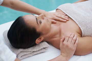 Hands, woman and luxury at spa for massage, skin care and wellness for health, therapy and peace. Female person, lady and relax for zen, body and tranquil on table, calm and wellbeing near pool