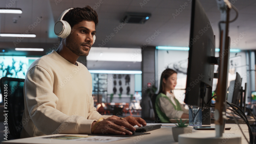 Aufkleber Indian Male Game Designer Using Desktop Computer With 3D Modelling Software To Design Unique Characters And World For Immersive RPG Video Game. Man Working In Game Development Company Diverse Office