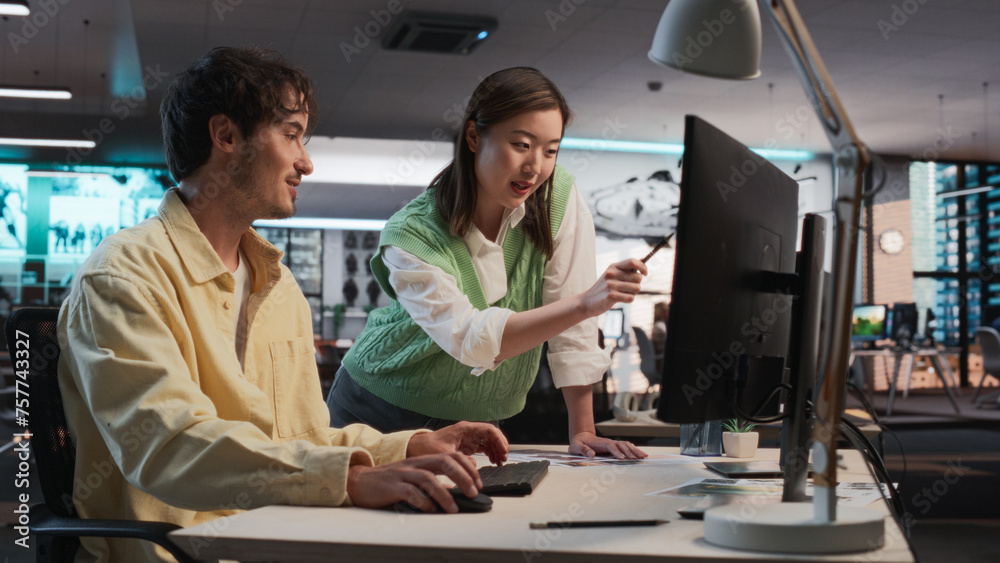 Poster Caucasian Male Game Designer Using Desktop Computer With 3D Modelling Software And Talking to Asian Female Project Manager in Game Development Studio Office. Diverse Colleagues Discussing New RPG Game