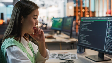 Female Asian Game Programmer Coding On Desktop Computer In Game Development Studio Diverse Office....