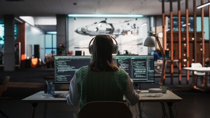 Creative Office: Professional Female Programmer Uses Headphones, Working on Desktop Computer....
