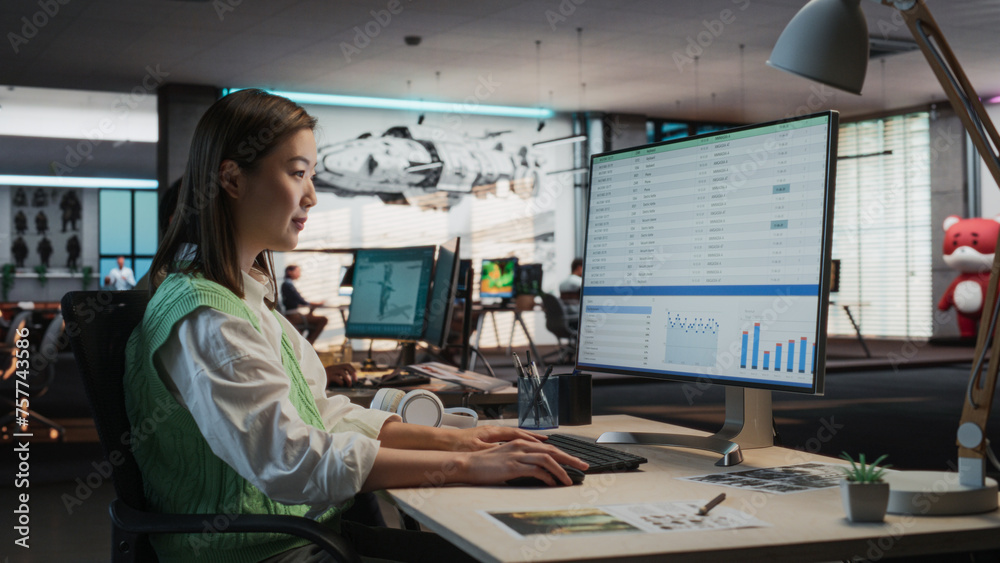Aufkleber Female Asian Manager Working on Desktop Computer With Analytics Reporting Software on Display in Office. Stylish Woman Analyzing Financial Data