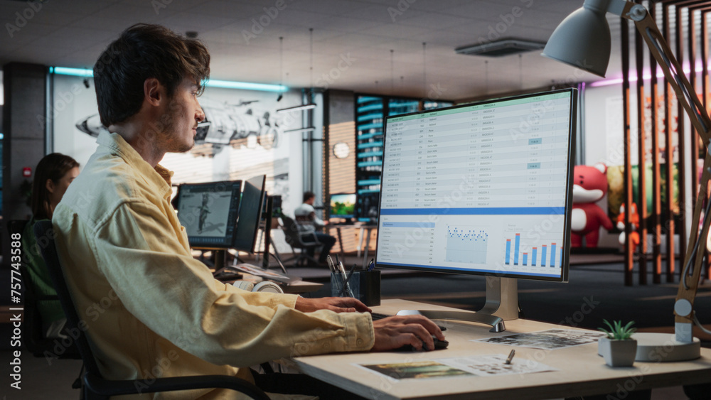 Poster Caucasian Male Manager Using Desktop Computer With Analytics Software wth Financial Reports. Man Working In Game Development Company Diverse Office