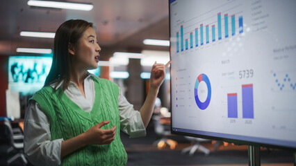 Creative Office Meeting: Portrait of Beautiful Asian Female Project Manager Presenting Goals For Marketing Strategy, Uses TV Set with Data Analysis, eCommerce Infographics - obrazy, fototapety, plakaty