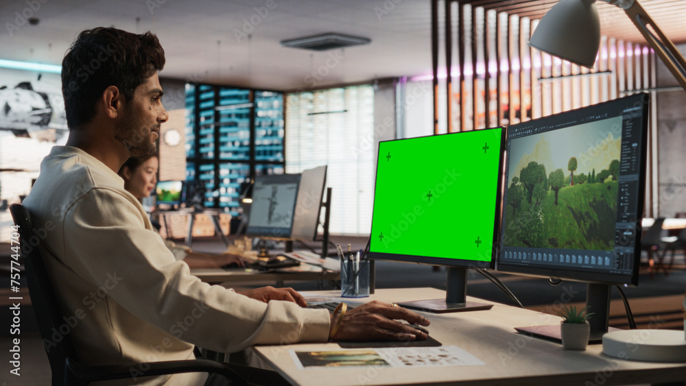 Aufkleber Indian Male Game Designer Using Desktop Computer With Green Screen Chromakey on Display, Designing Immersive World In 3D modelling Software For RPG Video Game. Man Working In Game Development Office